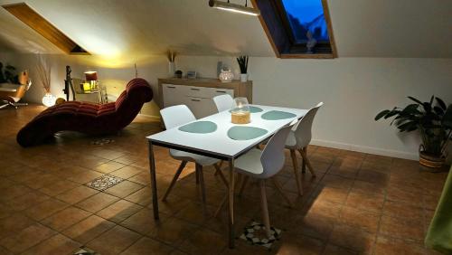 a dining room with a white table and white chairs at Surforama Studio Apartment mit Meerblick und Garten in Fehmarn