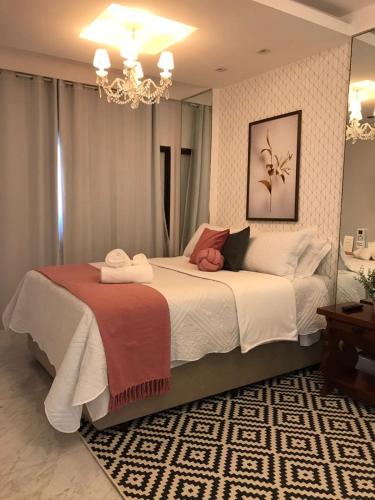 um quarto com uma cama grande e um lustre em Charmoso Apartamento em Ipanema no Rio de Janeiro