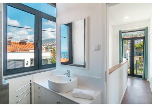 a bathroom with a sink and large windows at Casa Lanço with Spectacular View in Funchal