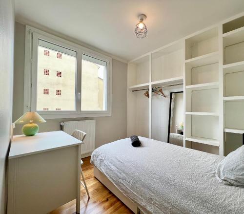 une chambre avec un lit, un bureau et une fenêtre dans l'établissement Paisible T3 proche métro, WI-FI & terrasse privée, à Toulouse