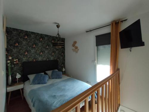 a bedroom with a bed with blue sheets and a window at DANTIN laurent in Le Crotoy