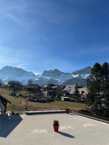 a potted plant sitting on a patio with mountains in the background at Hotel le Chalet in Gresse-en-Vercors