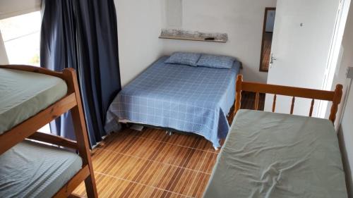 a bedroom with two bunk beds and a wooden floor at Pousada Do Léo in Bertioga
