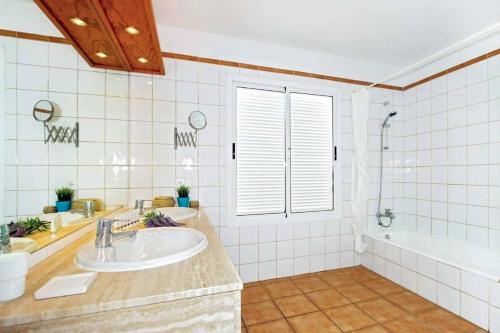 een badkamer met een wastafel, een douche en een bad bij Villa Alcazar in Playa Blanca