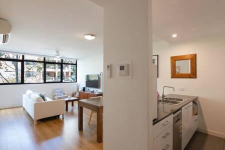 a kitchen and living room with a couch and a table at Treetops Erskineville Apartment w Parking & Aircon in Sydney