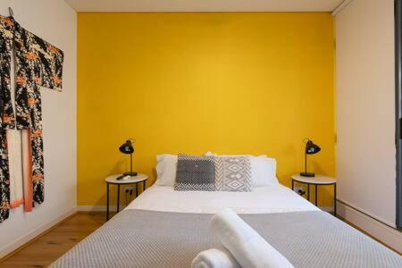 a bedroom with a bed with a yellow wall at Treetops Erskineville Apartment w Parking & Aircon in Sydney