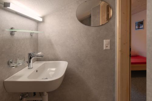 a bathroom with a sink and a mirror at Lehmann's Herberge Hostel in Grindelwald