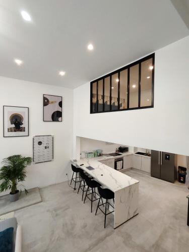 une cuisine blanche avec une table et des chaises dans une pièce dans l'établissement Beautiful apartments & Loft in Beziers center, à Béziers