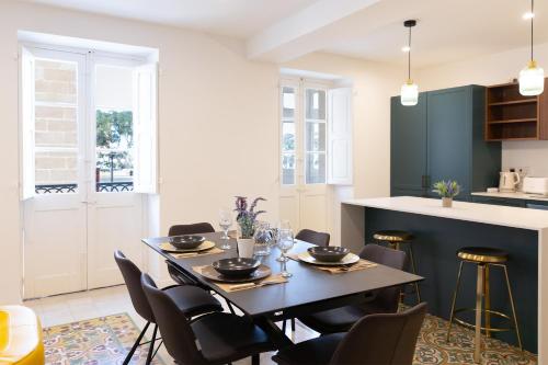 a dining room with a table and chairs at Florette Suite Designer Finish with Stunning Lounge Terrace by ArcoBnb in Il-Furjana