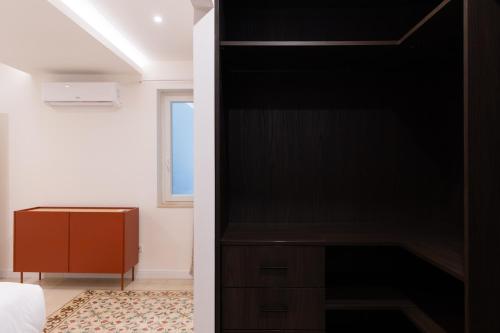 a bedroom with a black closet with a bed and a window at Florette Suite Designer Finish with Stunning Lounge Terrace by ArcoBnb in Il-Furjana