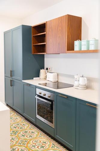 a kitchen with blue cabinets and an oven at Florette Suite Designer Finish with Stunning Lounge Terrace by ArcoBnb in Il-Furjana