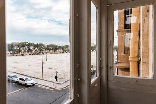 an open window with a view of a parking lot at Florette Suite Designer Finish with Stunning Lounge Terrace by ArcoBnb in Il-Furjana