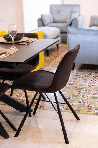 a dining table and chairs in a living room at Florette Suite Designer Finish with Stunning Lounge Terrace by ArcoBnb in Il-Furjana