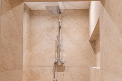a shower with a glass shower head in a bathroom at Florette Suite Designer Finish in Floriana in Il-Furjana