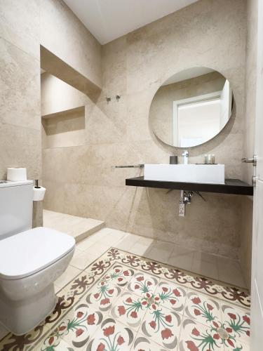 a bathroom with a toilet and a sink and a mirror at Florette Suite Designer Finish with Stunning Lounge Terrace by ArcoBnb in Il-Furjana