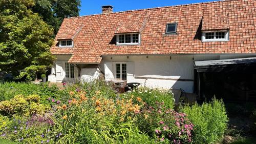 a house with a red roof and some flowers at La Plonploniere in Aix-en-Issart