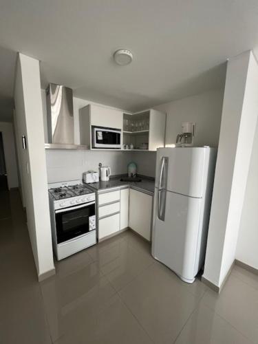 a kitchen with a white refrigerator and a stove at Departamentos y monoambientes Santiago 115 in Neuquén
