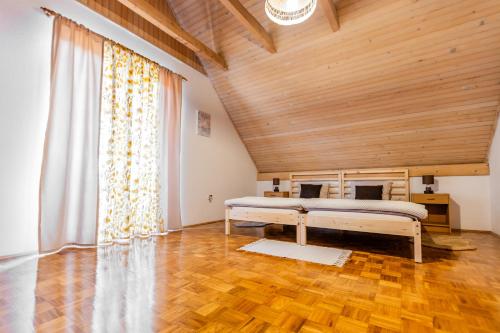 a bedroom with a bed and a wooden ceiling at Kuća za odmor Pristaš in Nova Gradiška