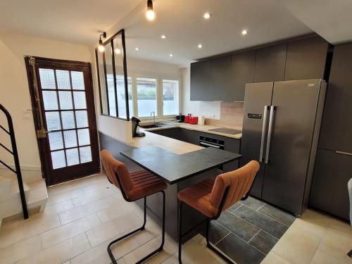 une cuisine avec une table et un réfrigérateur dans l'établissement Magnifique Maison proche centre-ville/ Climatisée, à Montpellier