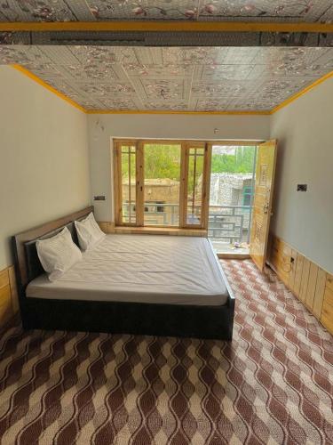 FIZA GUESTHOUSE في Dah: سرير كبير في غرفة مع نافذة كبيرة