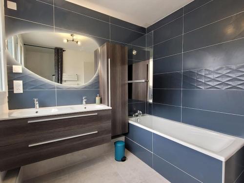 une salle de bain avec une baignoire, un lavabo et un miroir dans l'établissement Magnifique Maison proche centre-ville/ Climatisée, à Montpellier