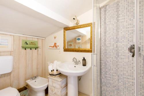 une salle de bain avec un lavabo, des toilettes et un miroir dans l'établissement L'Appartement De Sophie YourHostHelper, à Saint-Tropez