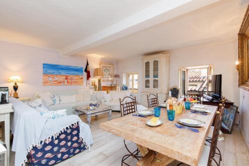 un salon avec une table et un canapé dans l'établissement L'Appartement De Sophie YourHostHelper, à Saint-Tropez
