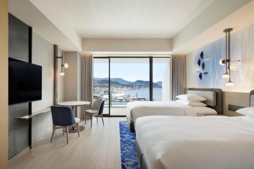um quarto de hotel com duas camas e uma televisão em Nagasaki Marriott Hotel em Nagasaki