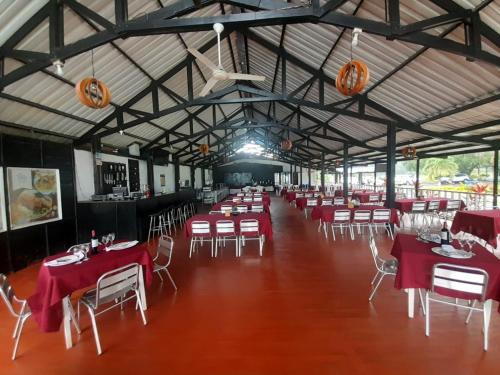 a banquet hall with red tables and white chairs at Hotel & Resort Villa del Sol in Tumaco