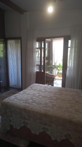 a bedroom with a bed in a room with windows at Casa Magia in Bombinhas
