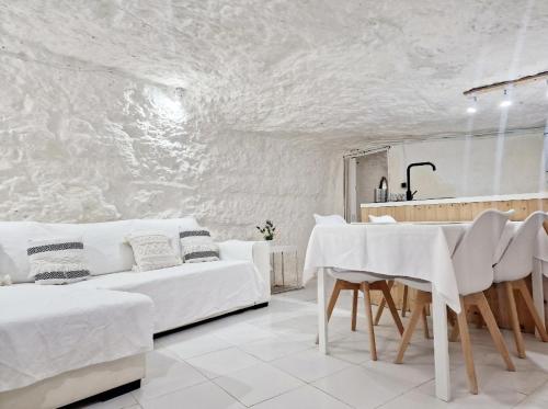 Sala de estar blanca con sofá blanco y mesa en Casa Cueva a 15 minutos del centro de Valencia en Paterna