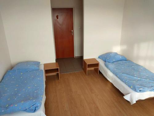 a bedroom with two beds and a hallway with a door at Pokoje Urzędnicza Kielce in Kielce
