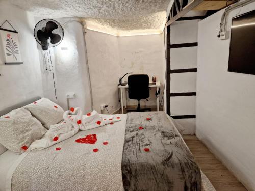 BONITA CASA CUEVA CON JACUZZI في باتيرنا: غرفة نوم مع سرير مع زهور حمراء عليه