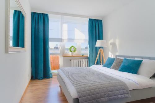 Mieszkanie do wynajęcia w centrum Kraśnika في كراسنيك: غرفة نوم بسرير كبير مع ستائر زرقاء