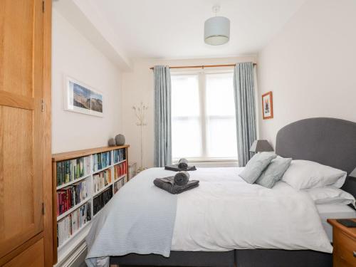 1 dormitorio con 1 cama y estantería con libros en Walla Crag, Royal Oak House, en Keswick