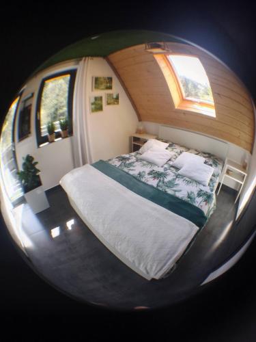 a small bedroom with a bed in a round mirror at Zaciszny Zakątek Zawoja in Zawoja