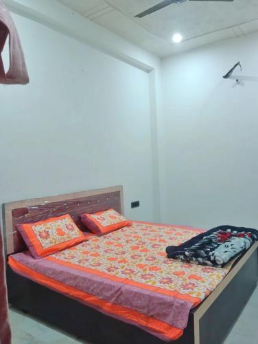 a bedroom with a bed with orange pillows at Kishore villa fully furnished house in Jaipur