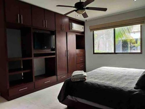 1 dormitorio con 1 cama y ventilador de techo en Ubicación privilegiada con encanto local. en Cozumel