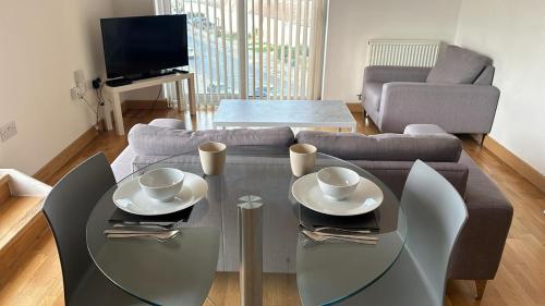 a living room with a table and a couch at Modern 2 bed flat with balcony in Southend-on-Sea