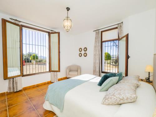 um quarto com uma cama grande e 2 janelas em Cubo's Hacienda El Baldio em Alcalá del Valle