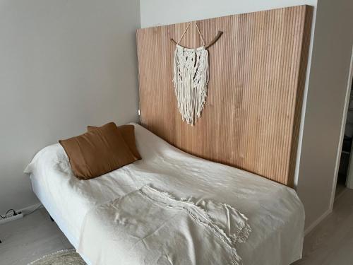 a bedroom with a bed with a wooden head board at Avara keskusta asunto + oma ilmainen parkkipaikka in Tampere
