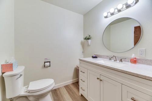 a white bathroom with a toilet and a mirror at Fern Hill Retreat in Chehalis