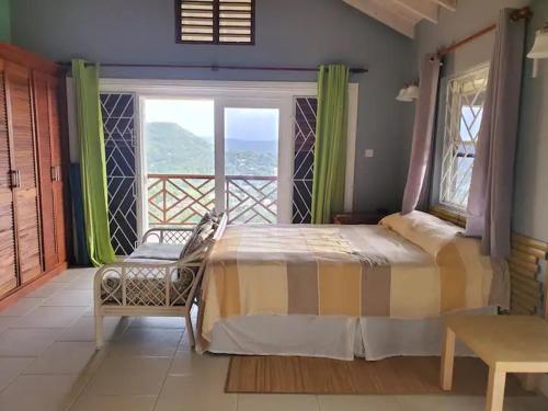 a bedroom with a large bed and a balcony at Nia's Hillside Loft - Exquisite Views in Gros Islet