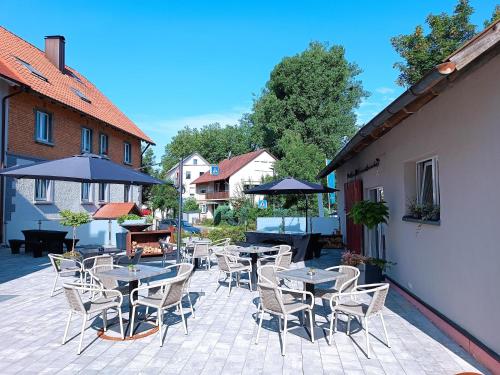 a patio with tables and chairs and umbrellas at Franzl Hof Zorell in Ravensburg