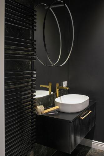 a bathroom with two sinks and a mirror at Srebrna Luxury Apartments - willa fabrykancka - wnętrza premium in Łódź