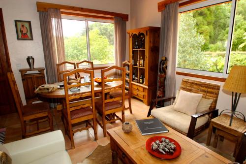 a living room with a table and chairs and a dining room at Bio Quinta do Pantano, Agro Turismo in Santo da Serra