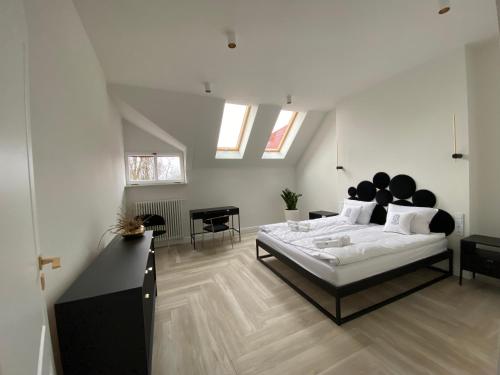 a bedroom with a large bed in a room with skylights at Srebrna Luxury Apartments - willa fabrykancka - wnętrza premium in Łódź
