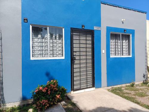 a blue and white house with two windows and a door at Hermosa y cómoda casita super cerca del Estadio El Kraken in Mazatlán