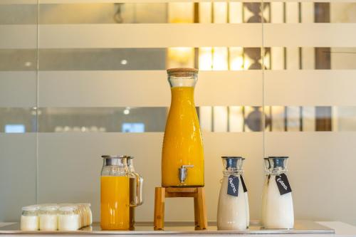a large bottle of orange juice next to two bottles of milk at Hotel Málaga Vibes in Málaga