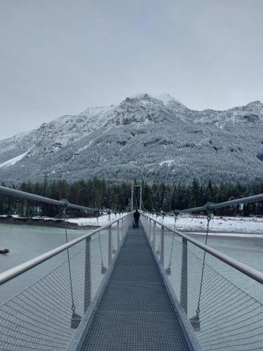 a bridge over a river with a mountain in the background at AlpApart Hornberg in Hofen